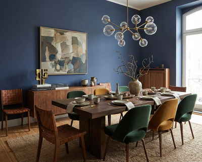 Esszimmer mit der Wandfarbe Cobalt Husk in tiefblauem Farbton, DIY-renoviert mit re-box Renovierungsbox, Holzesstisch, gepolsterte Stühle und moderne Pendelleuchte.