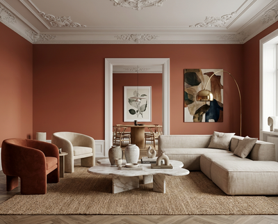 Wandfarbe Crimson Éclat von re-box aus der DIY Renovierungsbox den Wohnraum als tiefer, erdiger Rot-Terrakotta-Ton, der Stuckdecke, Sofa, Sessel und Marmortisch kontrastreich vor der gleichmäßig gestrichenen Wand hervorhebt und eine ruhige, hochwertige Raumwirkung erzeugt.