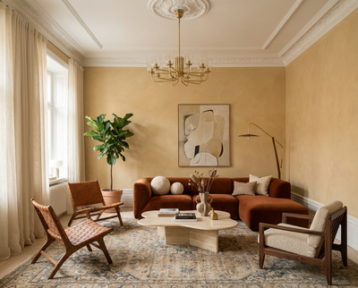 DIY-renoviertes Wohnzimmer mit der Wandfarbe Saffron Glow, warmer Gelbton, Sofa in Naturfarben und stilvolle Einrichtung – umgesetzt mit re-box Renovierungsbox.